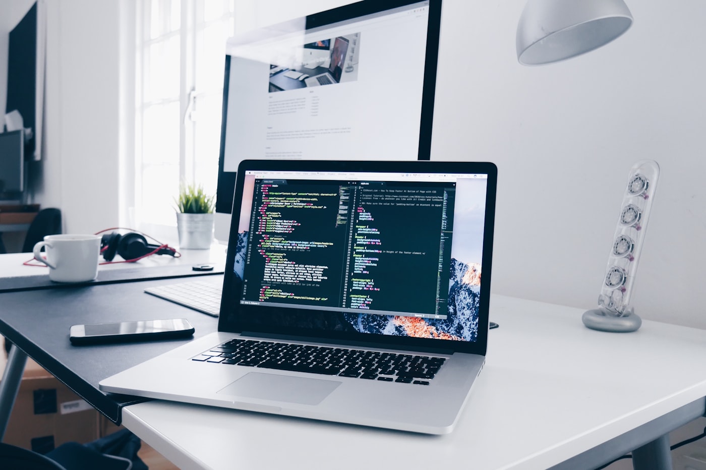 Code and browser windows on a laptop while saving a cloud video